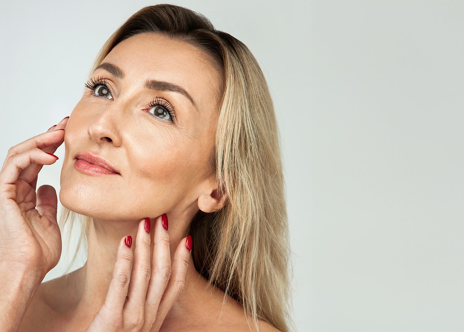 Woman touching her face with gentle expression.